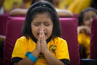 A young girl prays