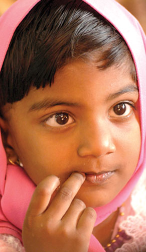 A girl wearing a pink head covering