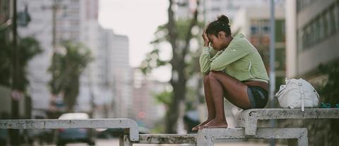 A girl sits on a concrete table in a city park
