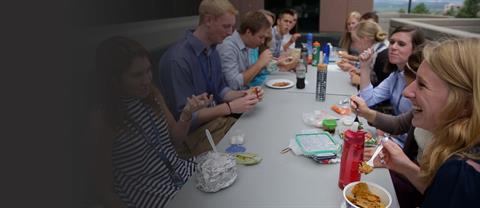 A group of interns eat together at a table