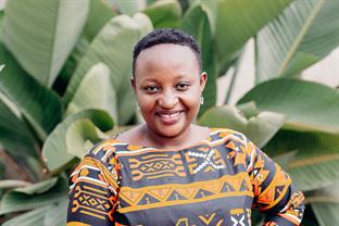 Justine smiles wearing a printed shirt