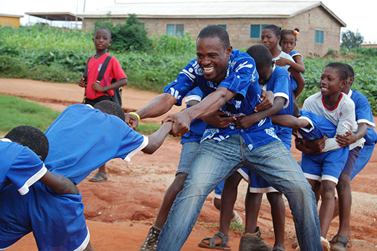 A teacher playing tug-of-war with his students