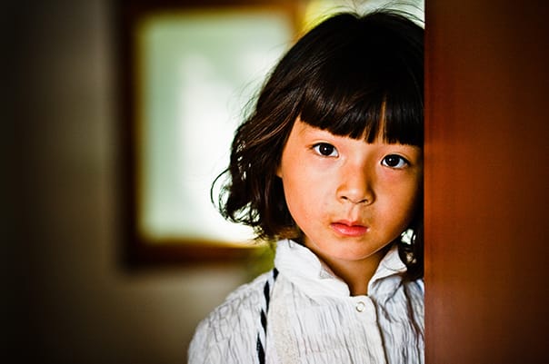 little girl looking from a doorway