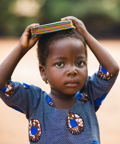 young child holding book on head