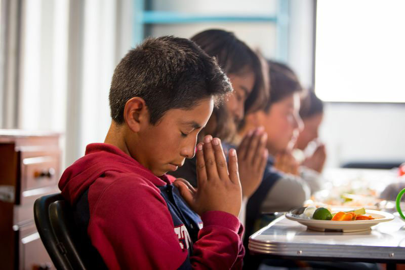 Children pray before a meal