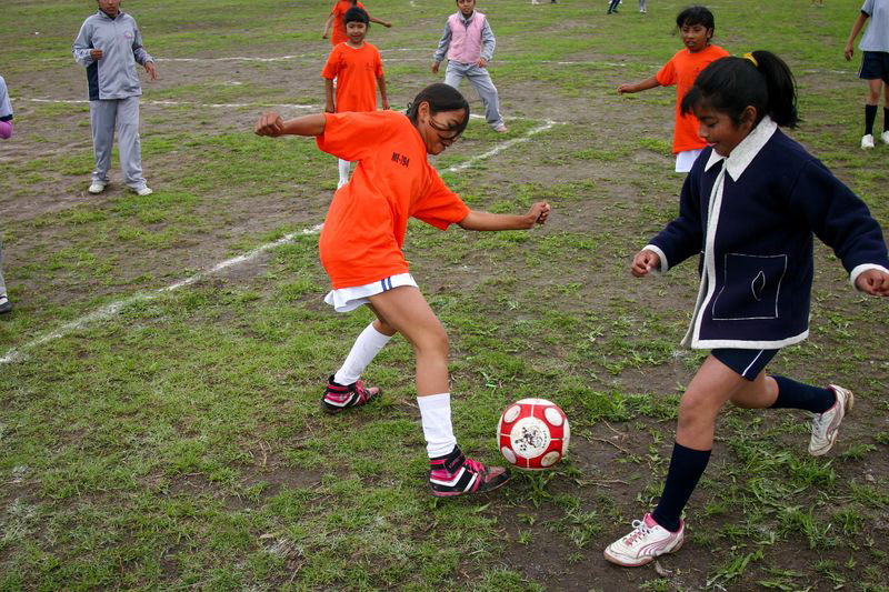 Children playing soccer on a field