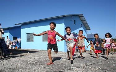 Children running and playing outside their homes