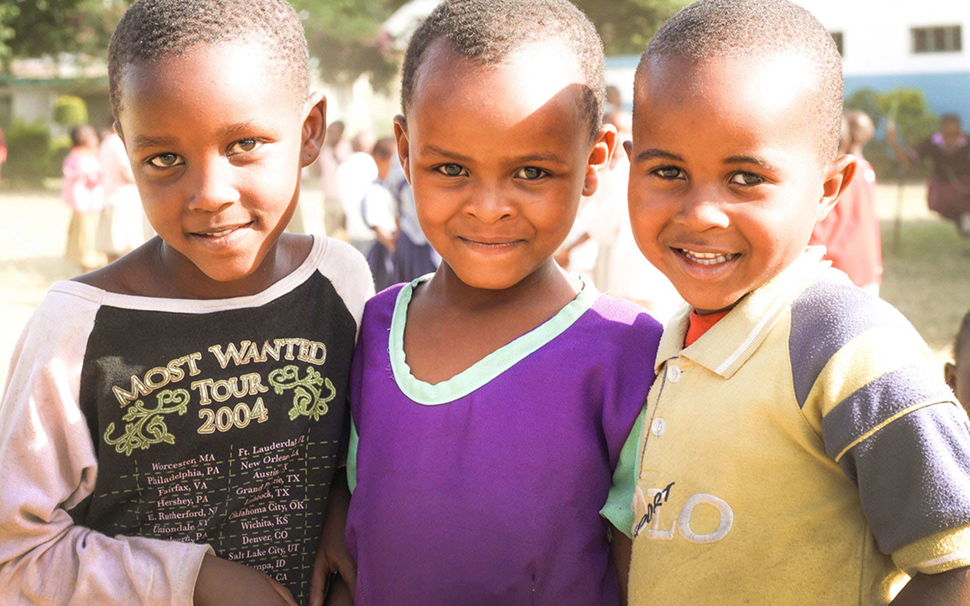 Three boys standing together at their child development center