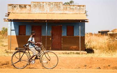 A boy in Uganda riding his bicycle