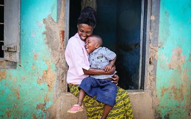 A mom holds her son who attends a Compassion Child Survival Program in Uganda