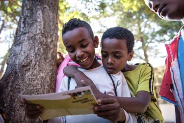 A boy in Ethiopia reads his Compassion sponsor letter