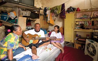 A girl listening to her father play the guitar