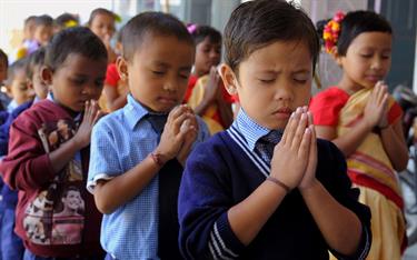 Children praying with their hands folded