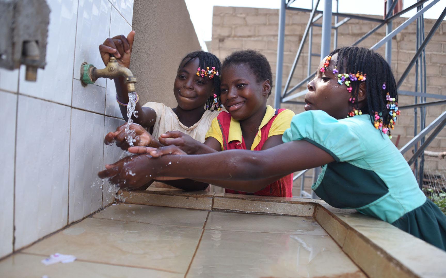 Girls washing their hands with clean water