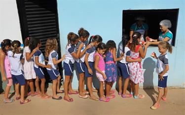 Sponsored kids line up for a snack outside their child development center