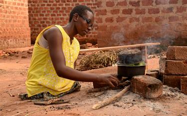 Grace prepares a meal on her outdoor stove