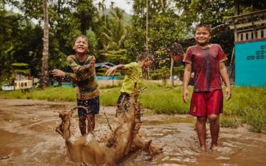 Kids spash in a mud puddle and laugh