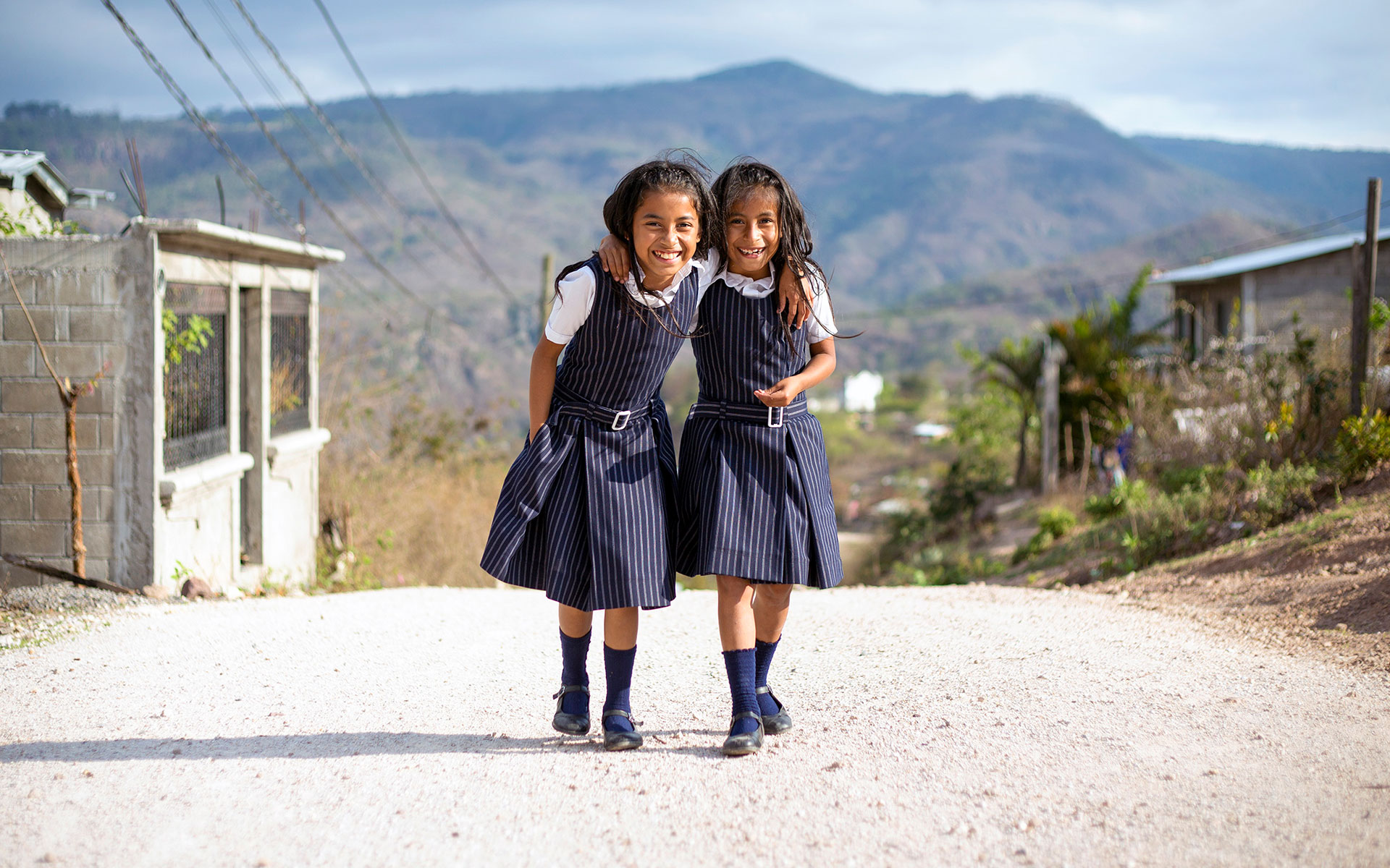 Two sisters smile while walking to school