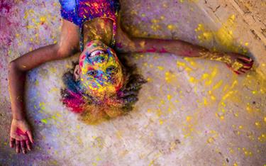 A Brazilian girl is covered in colorful powder outside her Compassion center.