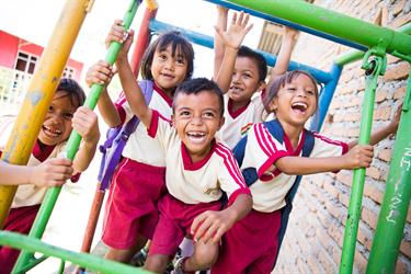 Children in Indonesia play on the playground at their Compassion center