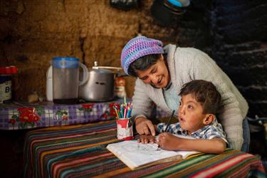 Jesus, 7, draws pictures at home in Peru with his mom