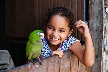 Maisa, a joyful 4-year-old in Brazil watches a bird