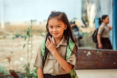 a young girl in Indonesia stands in her school uniform