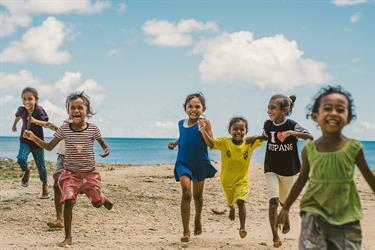 9-year-old Jani and her friends run on the beach in Indonesia