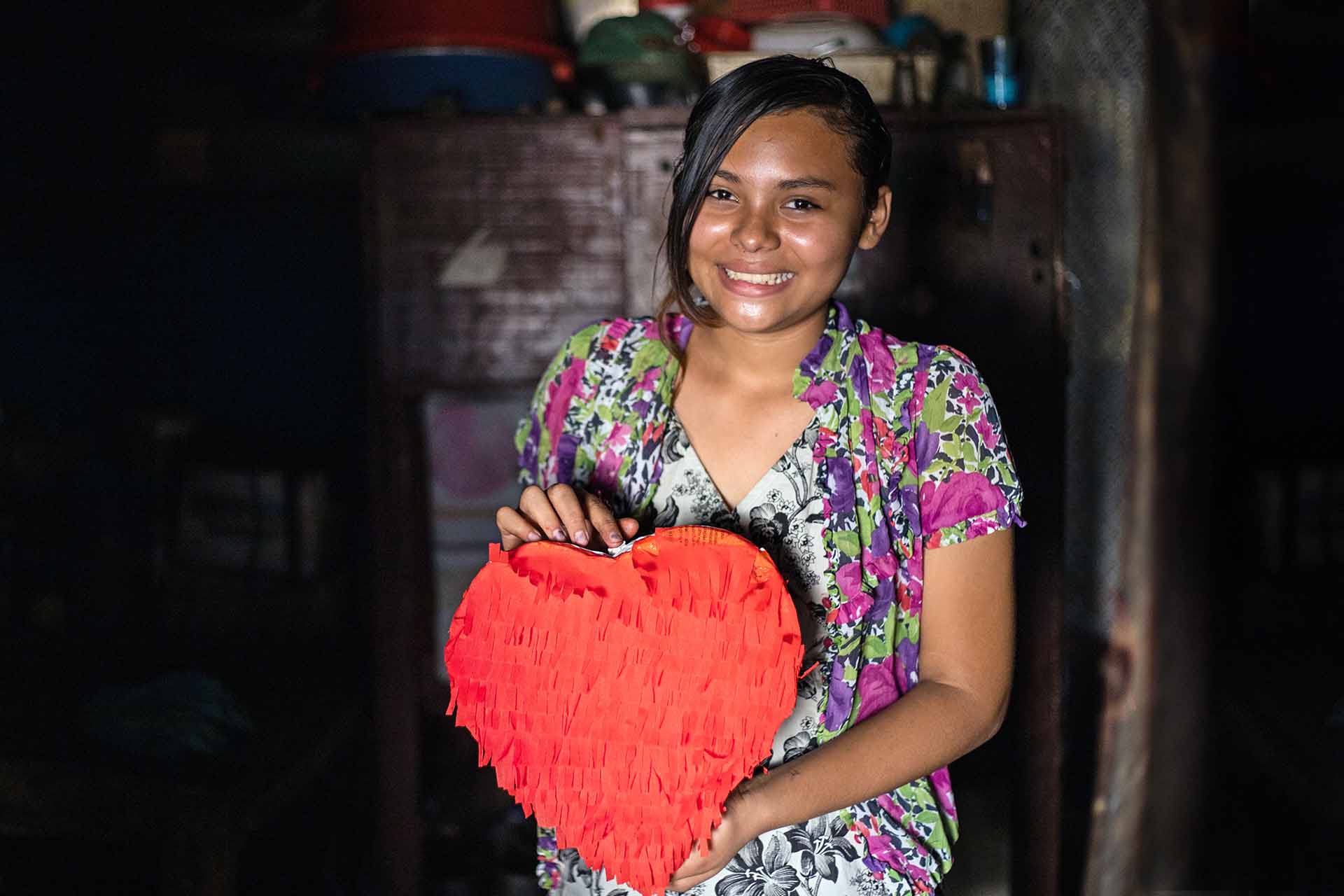 Estrella holds a piñata that she made at her Compassion center