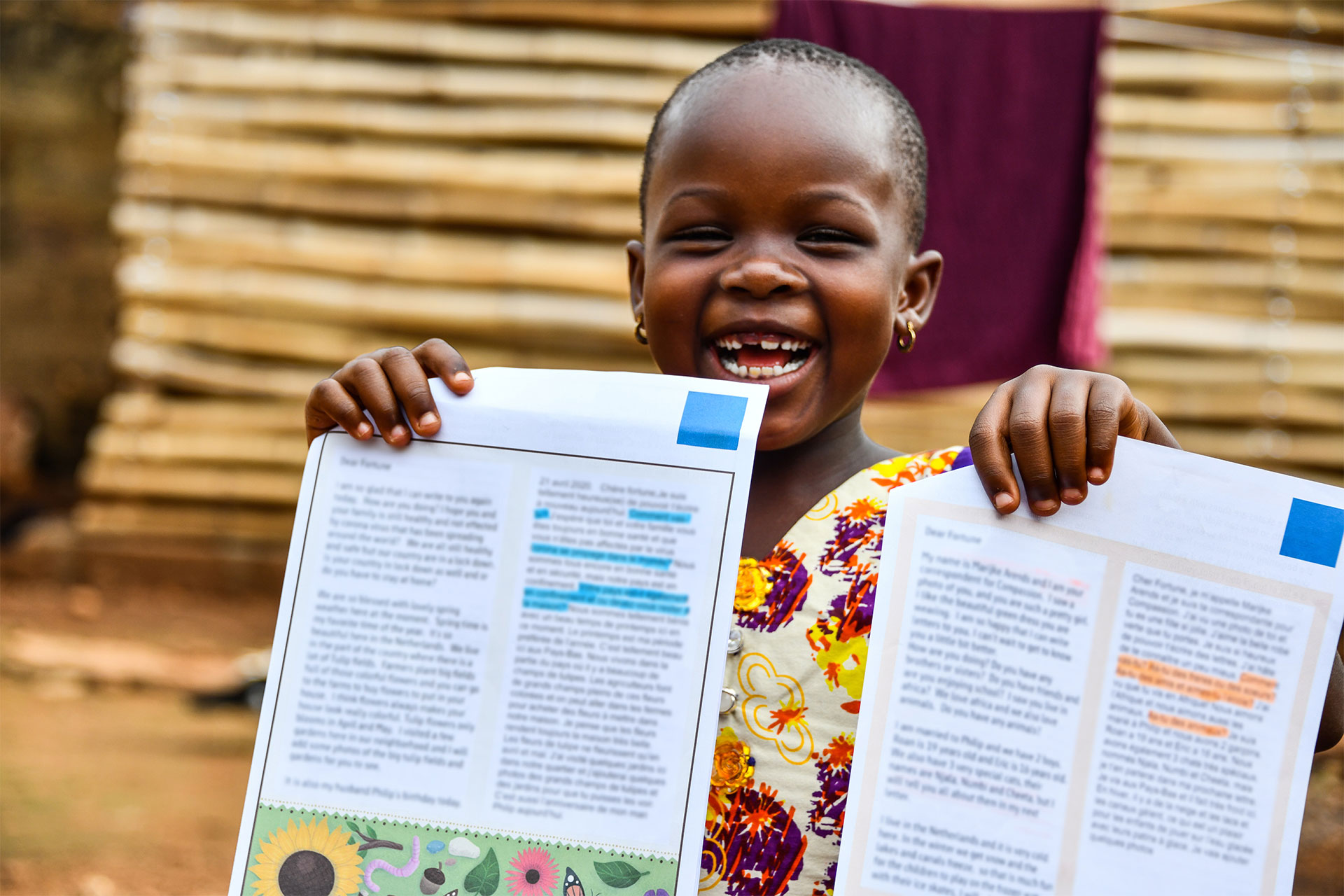 Fortune, a 6-year-old from Togo, holds letters from her sponsor