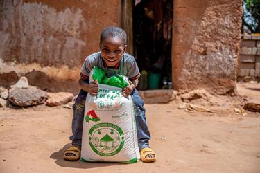 six-year-old Sylvain with a bag of rice for his family