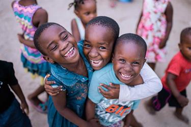 a group of boys smile outside their Compassion center in Tanzania
