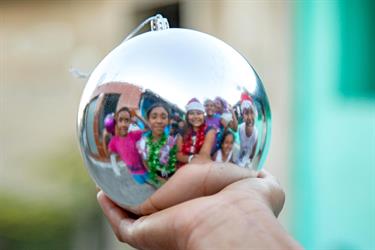 reflection in a Christmas ornament of children