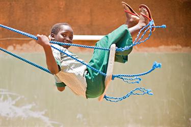 a boy swings at his Compassion center