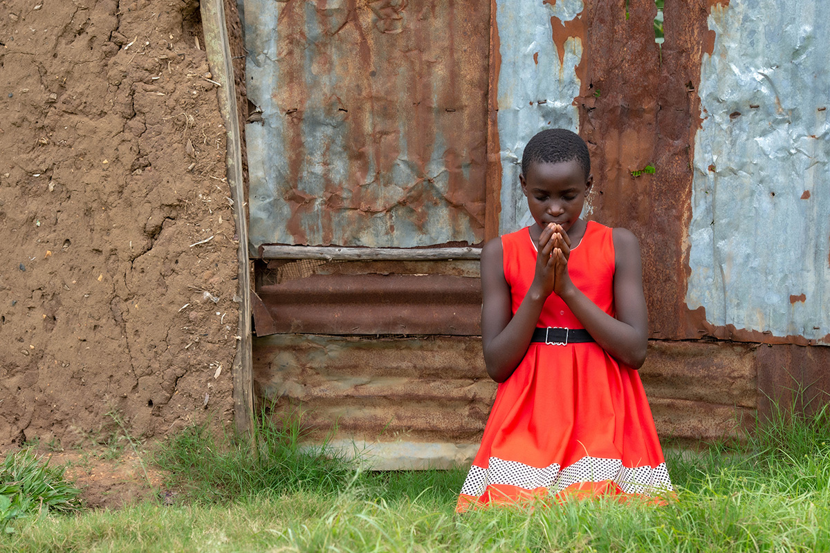 a girl kneels and prays