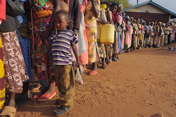 A young boy standing in line waiting for his family's food rations