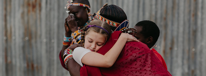 a girl hugs her sponsored child's mother