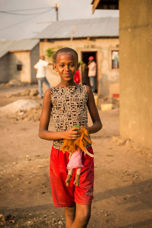 A girl walks outside her home in Rwanda
