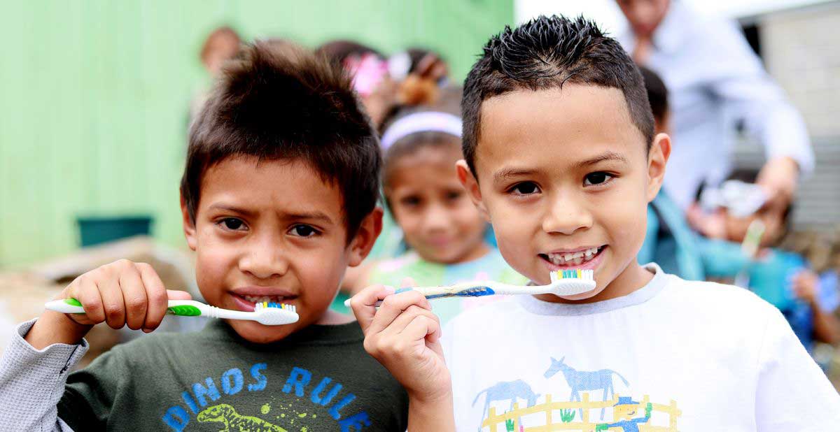 Boys learing good hygiene habits by brushing their teeth