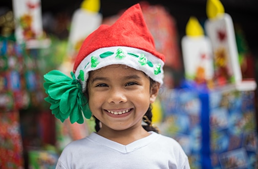 Smiling girl in a Santa hat.
