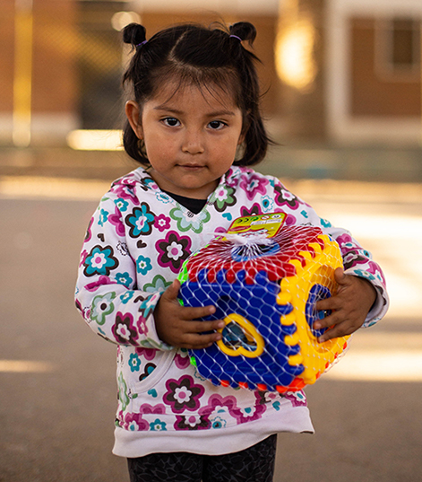 A girl holds a toy