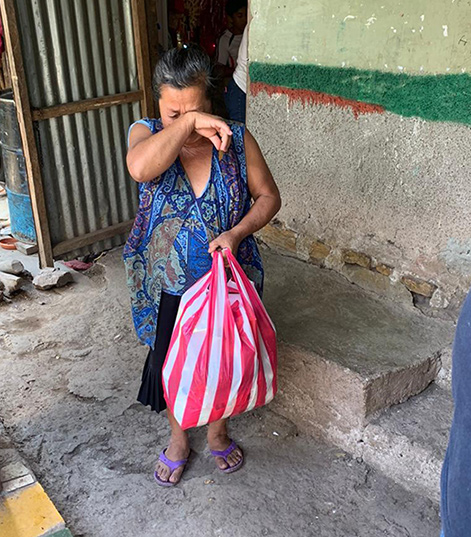 a woman breaks down in tears after receiving food