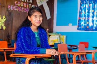 Eva sits in her classroom