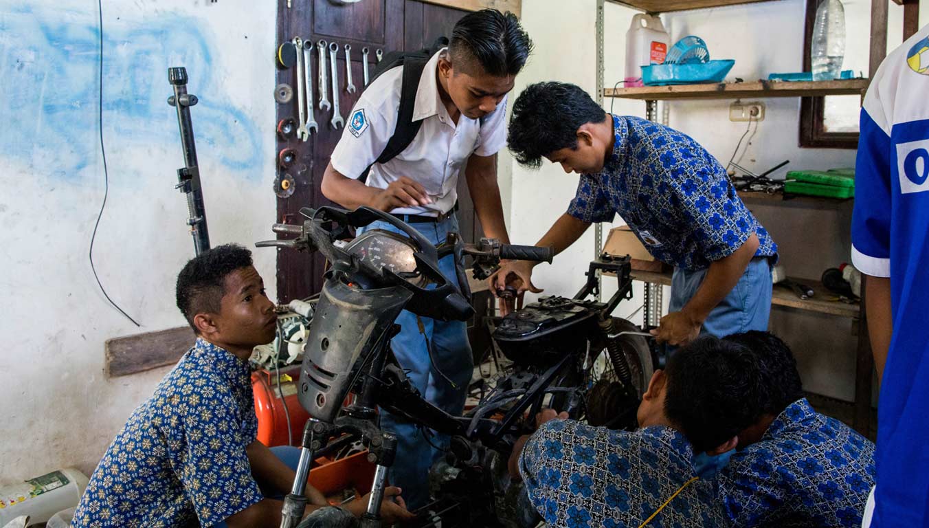 Boys learning automotive repair as a vocational skill in Indonesia