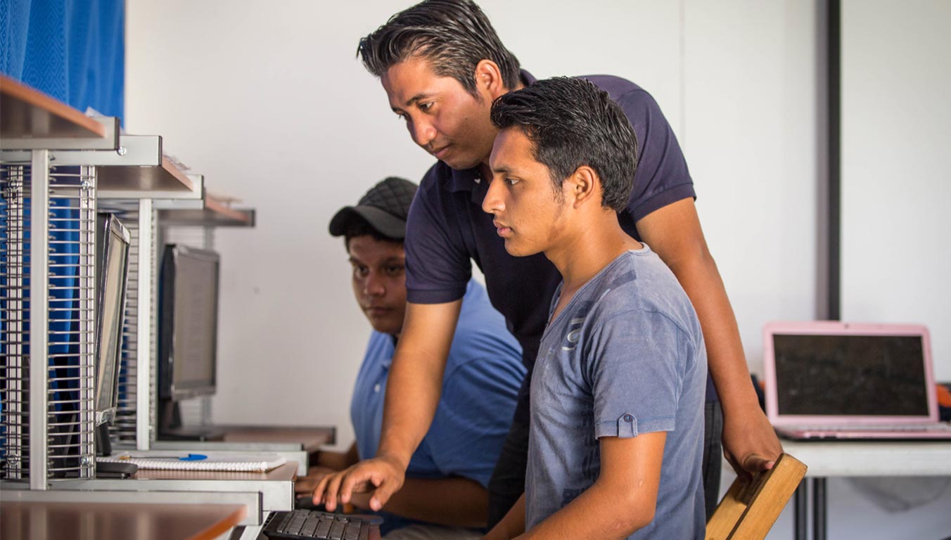 A young adult male learning computer skills in Mexico