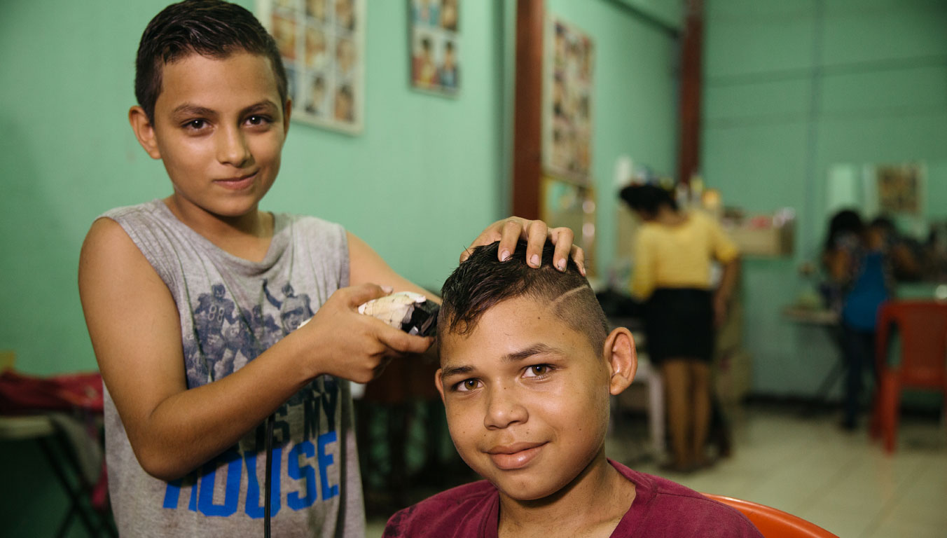 A boy learning how to cut hair as a vocational skill in Nicaragua