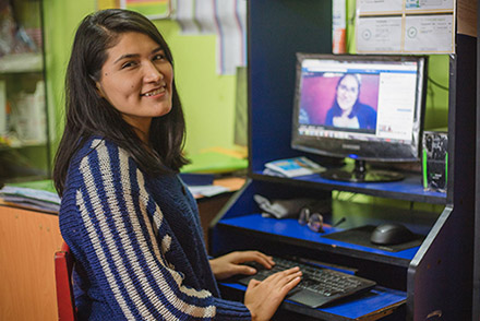 A young woman in front of a computer screen
