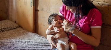 a mother holds her young baby