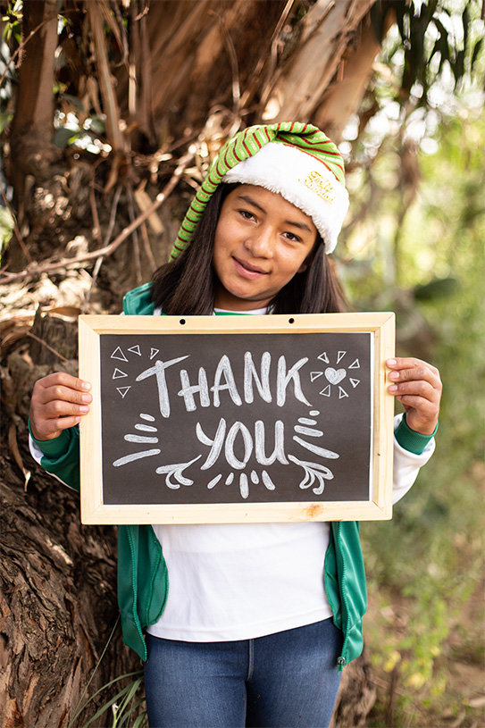 a girl holds a sign that says "Thank You"