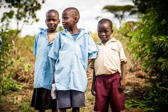 Three boys standing in a field showing compassion